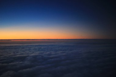 Güneş, uçak penceresinden batıyor.