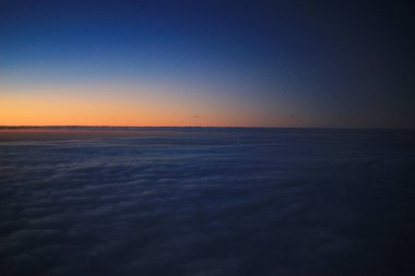 Güneş, uçak penceresinden batıyor.