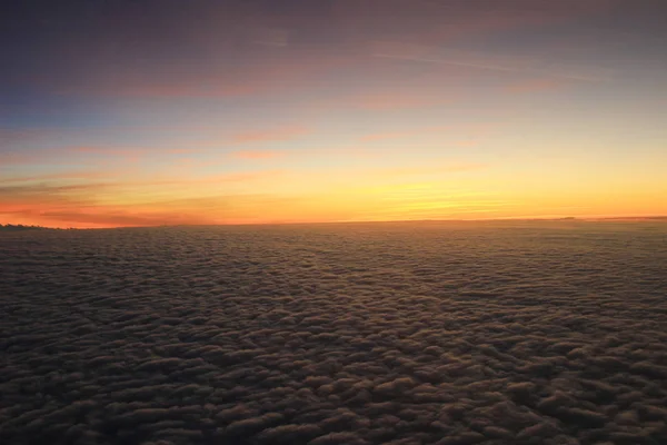 Der Blick auf den Sonnenuntergang aus dem Flugzeugfenster — Stockfoto