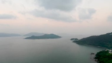 Limanda dağlar ve adalarla kaplı bulutlu gün batımı gökyüzü