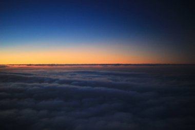 Güneş, uçak penceresinden batıyor.