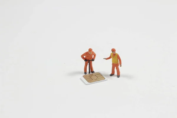 Ein Figurenarbeiter mit einer Mini-Sim-Karte — Stockfoto
