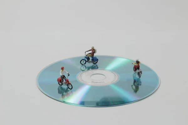 Group of traveler miniature people figures ride motorcycle on di