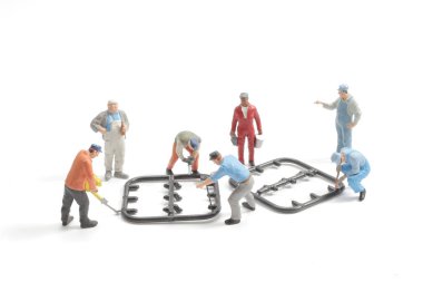 Mini İşçiler devre modelini beyazda onarıyor