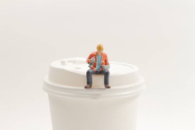 Kağıt bardakta oturan mini işçi figürleri.