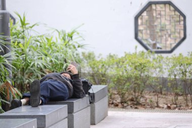 Parktaki bankta uyuyan evsiz bir adam