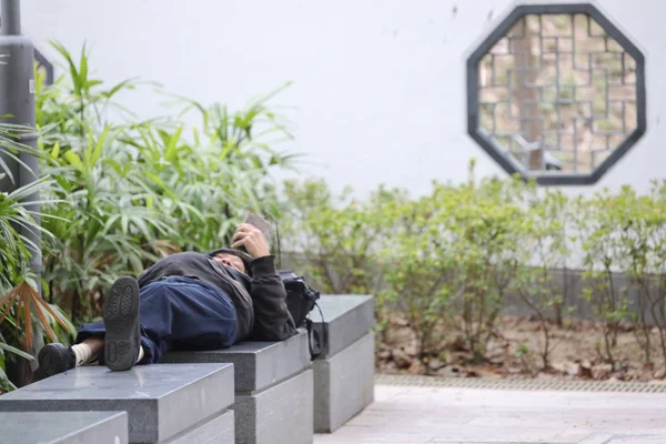 Parktaki bankta uyuyan evsiz bir adam