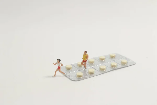 一组男人和女人用药丸跑步的缩影 — 图库照片