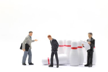 İş adamlarının minicik figürleri ve bowling topu