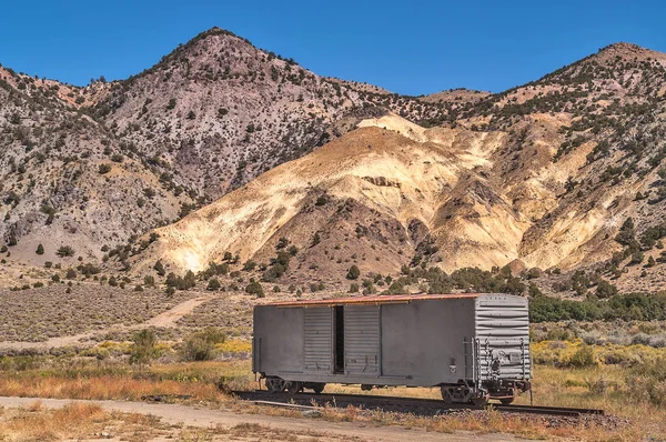 Voiture ferroviaire avec des montagnes derrière elle — Photo