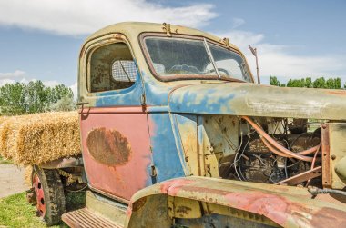 Close-up of old, colorful, vintage truck missing some parts and rusting in places clipart