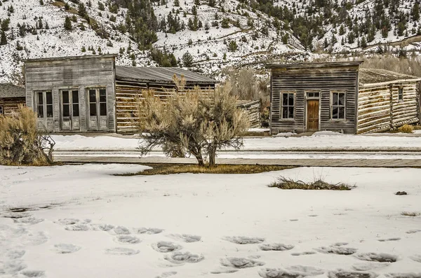 在街上和山上贴满春雪的圆木建筑物 — 图库照片