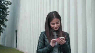 Smartphone gülümseyen ve manifatura App kullanarak kadın