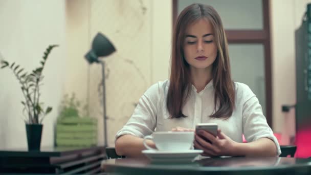 Mujer usando la aplicación en el teléfono inteligente en la cafetería — Vídeos de Stock