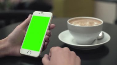 Bir cep telefonu ile yeşil ekran kullanan kadın