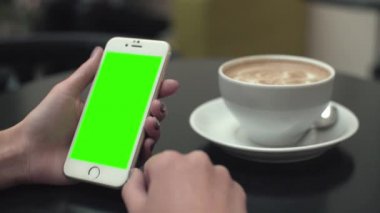 Bir cep telefonu ile yeşil ekran kullanan kadın
