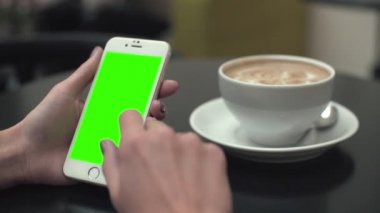 Bir cep telefonu ile yeşil ekran kullanan kadın