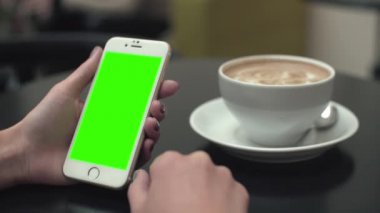 Bir cep telefonu ile yeşil ekran kullanan kadın