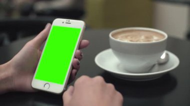 Bir cep telefonu ile yeşil ekran kullanan kadın