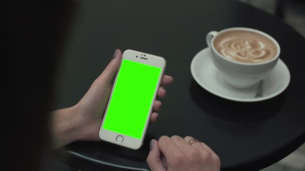Vrouw met behulp van een mobiele telefoon met groen scherm — Stockvideo