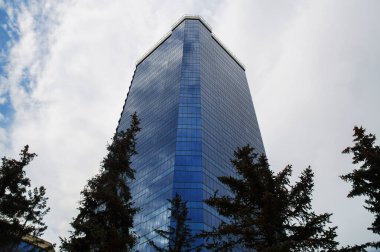 Aynalı duvarları olan yüksek cam gökdelen binası.