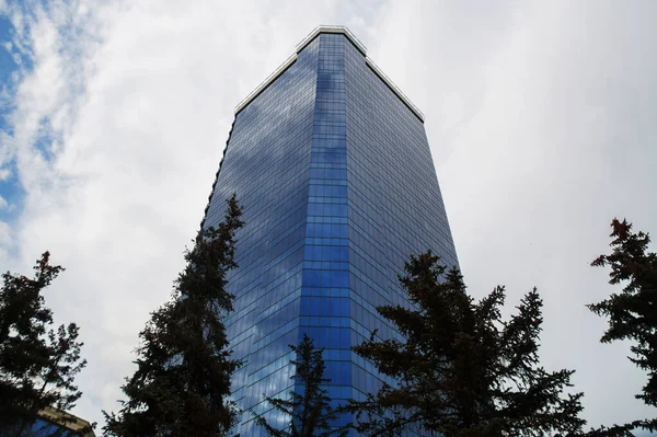 Edifício de arranha-céus de vidro alto com paredes espelhadas — Fotografia de Stock