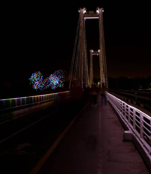 Ночной город с светящимся мостом и цветной подсветкой — стоковое фото