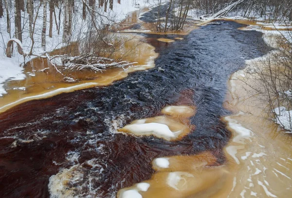 川の冬の風景を茶色の水と氷で — ストック写真
