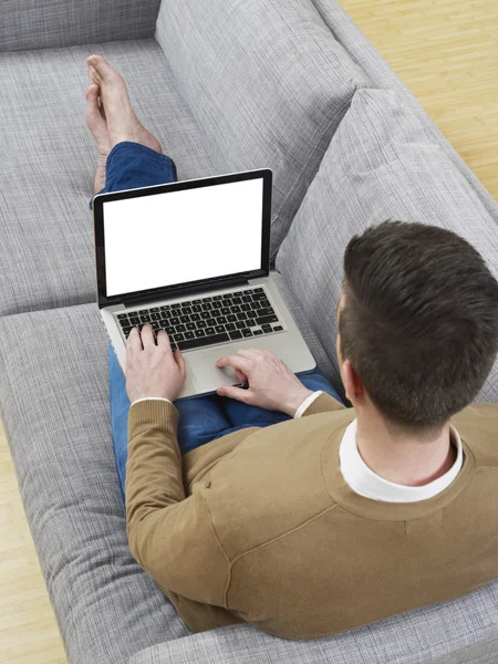 Mann auf Couch mit Laptop — Stockfoto