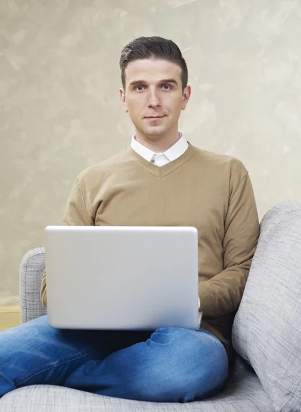 Mann mit Laptop schaut in Kamera — Stockfoto