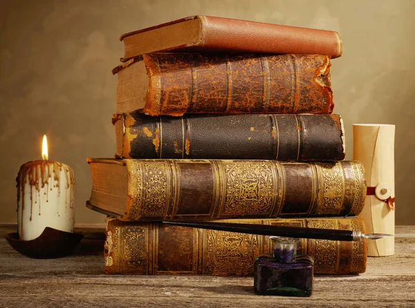 Чернильница, перо, свечи и антикварные книги — стоковое фото