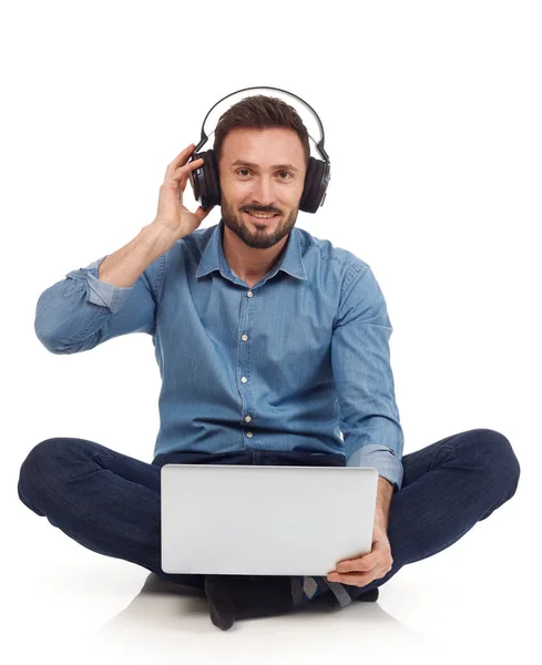 Άνθρωπος με φορητό υπολογιστή και ακουστικά — Φωτογραφία Αρχείου