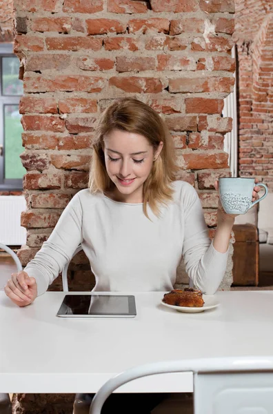 Flicka med kaffe och tablett — Stockfoto