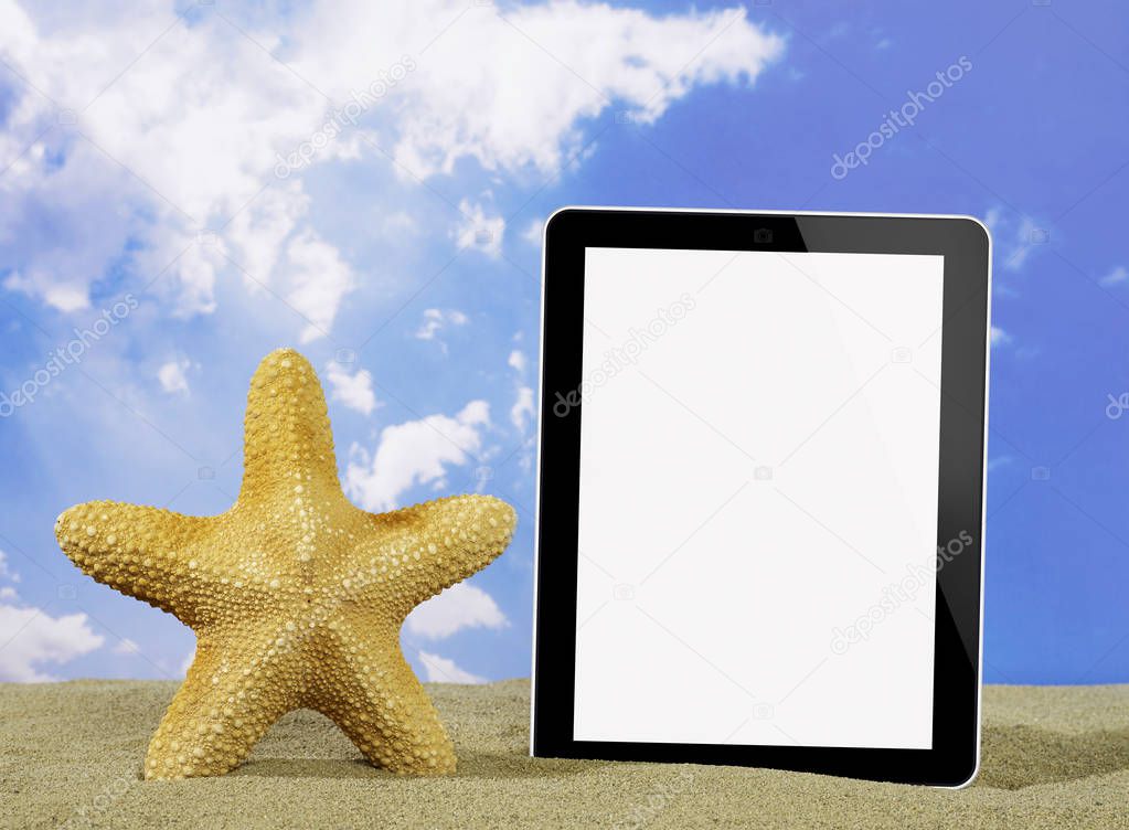 Starfish and digital tablet on beach