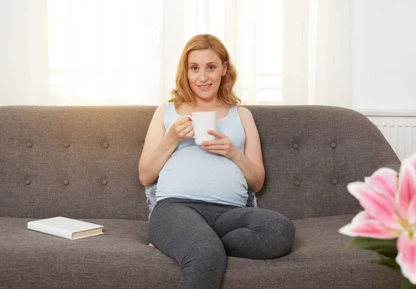 Zwangere vrouw ontspannen op de bank — Stockfoto