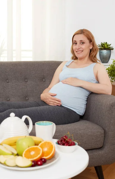 Zwangere vrouw met plaat van vruchten — Stockfoto