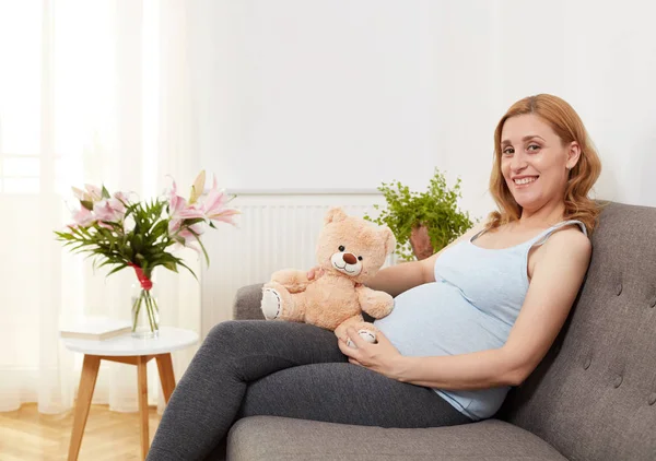 Zwangere jongedame met teddybeer — Stockfoto
