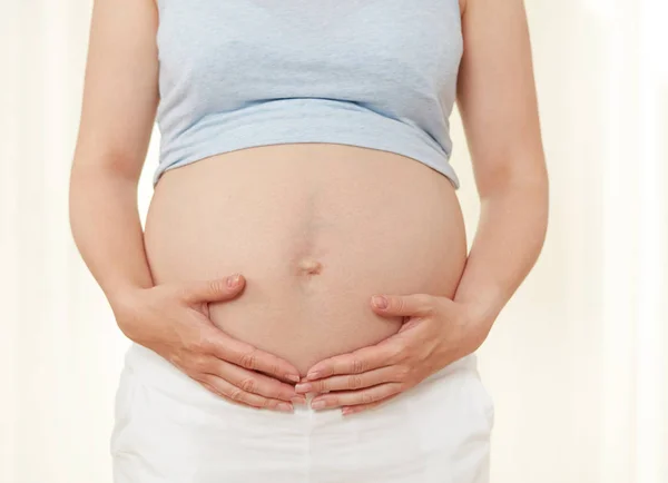 Mulher grávida mostrando seu abdômen — Fotografia de Stock
