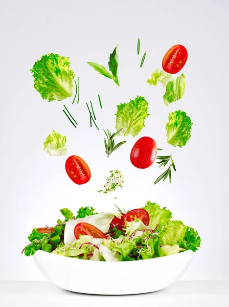 Salad falling in a bowl — Stock Photo, Image