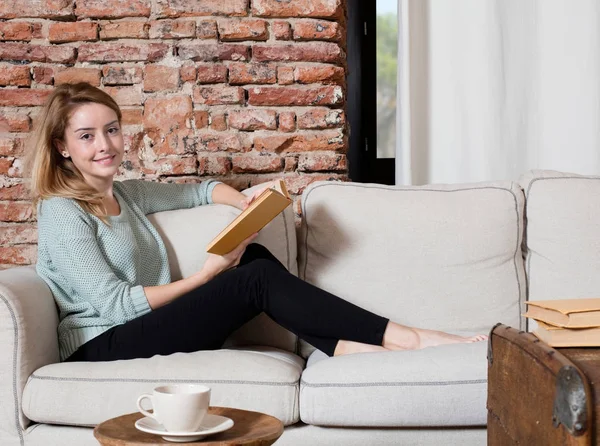 Fille avec livre sur canapé — Photo