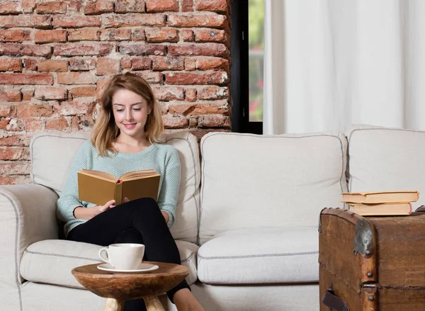 Reading a book on sofa — Stock Photo, Image