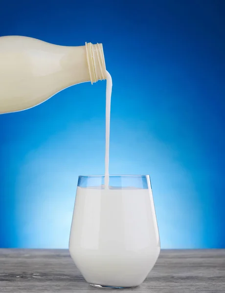 Milch in ein Glas gießen — Stockfoto