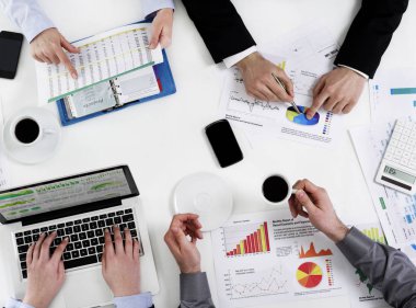 İnsanlar masada kağıtları gözden tartışıyor