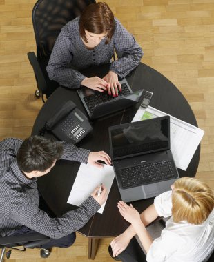 Masa başında çalışan kişilerin görünümünü yukarıda