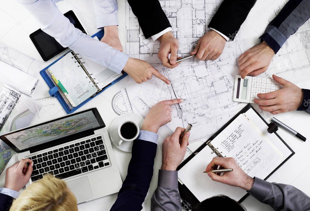 People discussing at table over papers