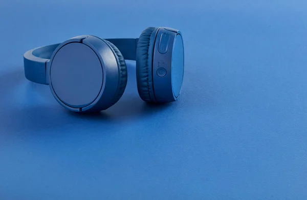 Draadloze koptelefoon op blauwe achtergrond — Stockfoto