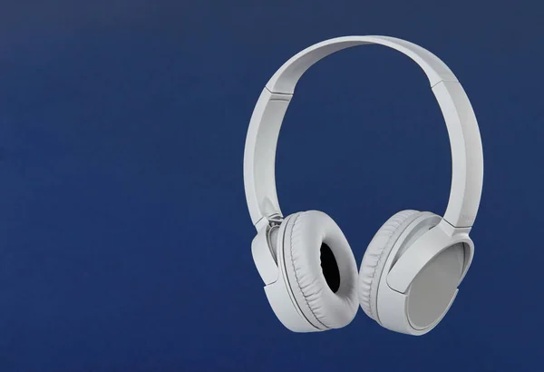Gray wireless headphones on blue background — 스톡 사진