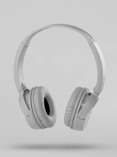 Сірі бездротові навушники на сірому фоні — стокове фото