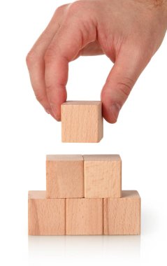 Businessman making a wooden blocks pyramid clipart