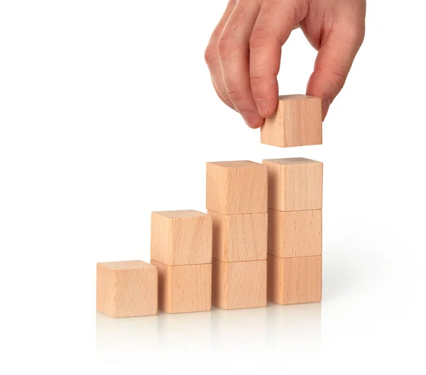 Closeup of man making bar chart with wooden cubes — Stock Photo, Image